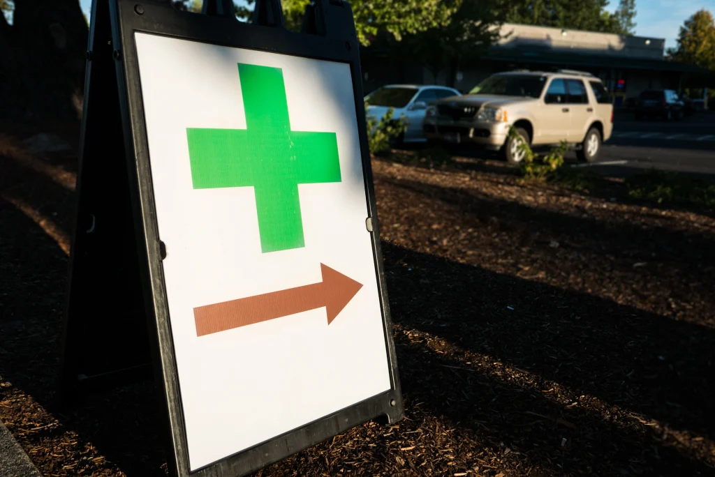 Marijuana dispensary sign with red arrow; buy weed in Miami